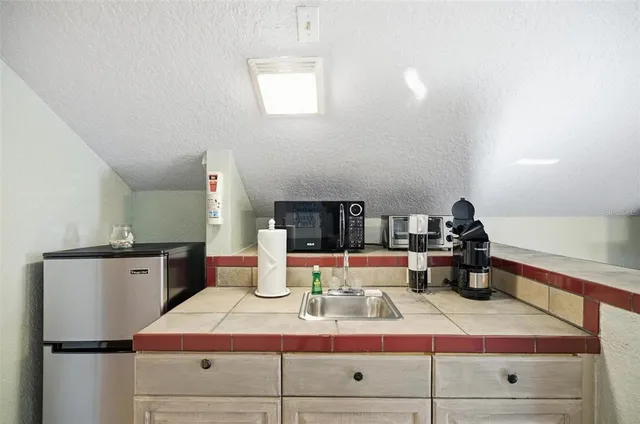 a kitchen with a refrigerator and a stove top oven