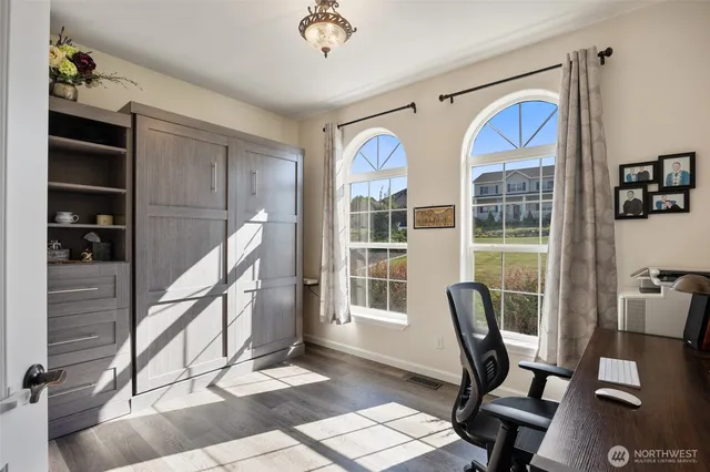 a view of a workspace with furniture and a window