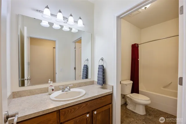 a bathroom with a granite countertop sink a toilet and a mirror