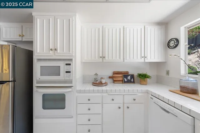 a kitchen with granite countertop cabinets a dining table and chairs