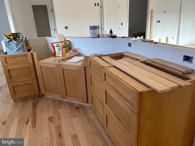 a kitchen with wooden floors and white walls