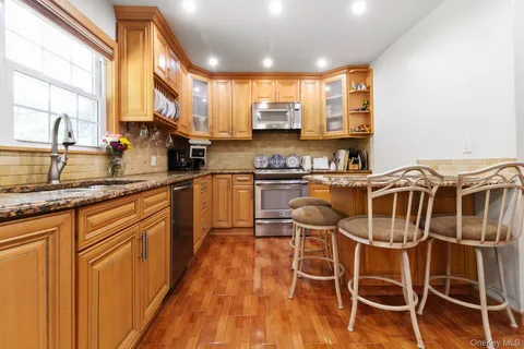 a kitchen with stainless steel appliances a table and chairs in it
