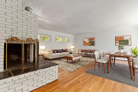 a living room with fireplace furniture and a rug