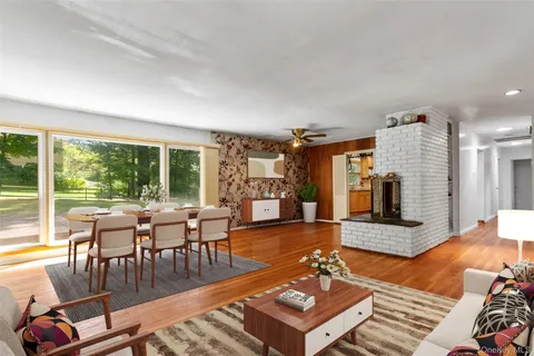 a living room with furniture a flat screen tv and a floor to ceiling window