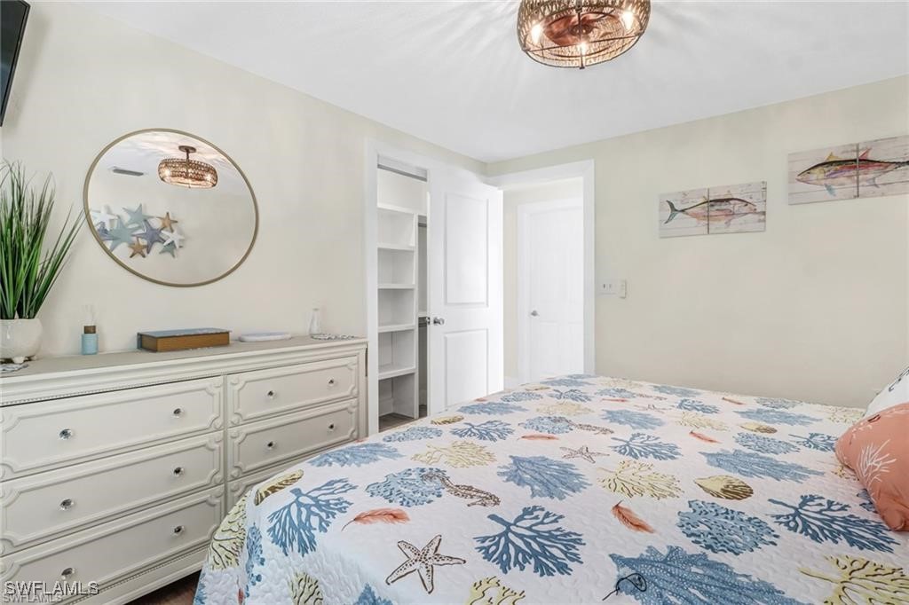 2686 Clyde Street Matlacha, FL 33993 - Photo 23 of 36 a bedroom with a bed a clock on the wall and dresser
