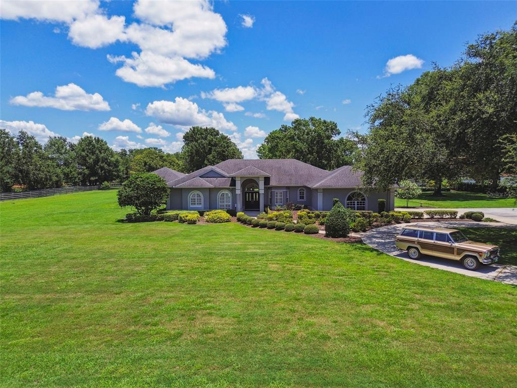 17603 Crawley Road Odessa, FL 33556 - Photo 1 of 1 a front view of a house with garden and trees