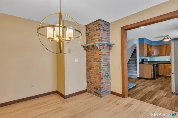 a view of a livingroom with wooden floor and a kitchen space