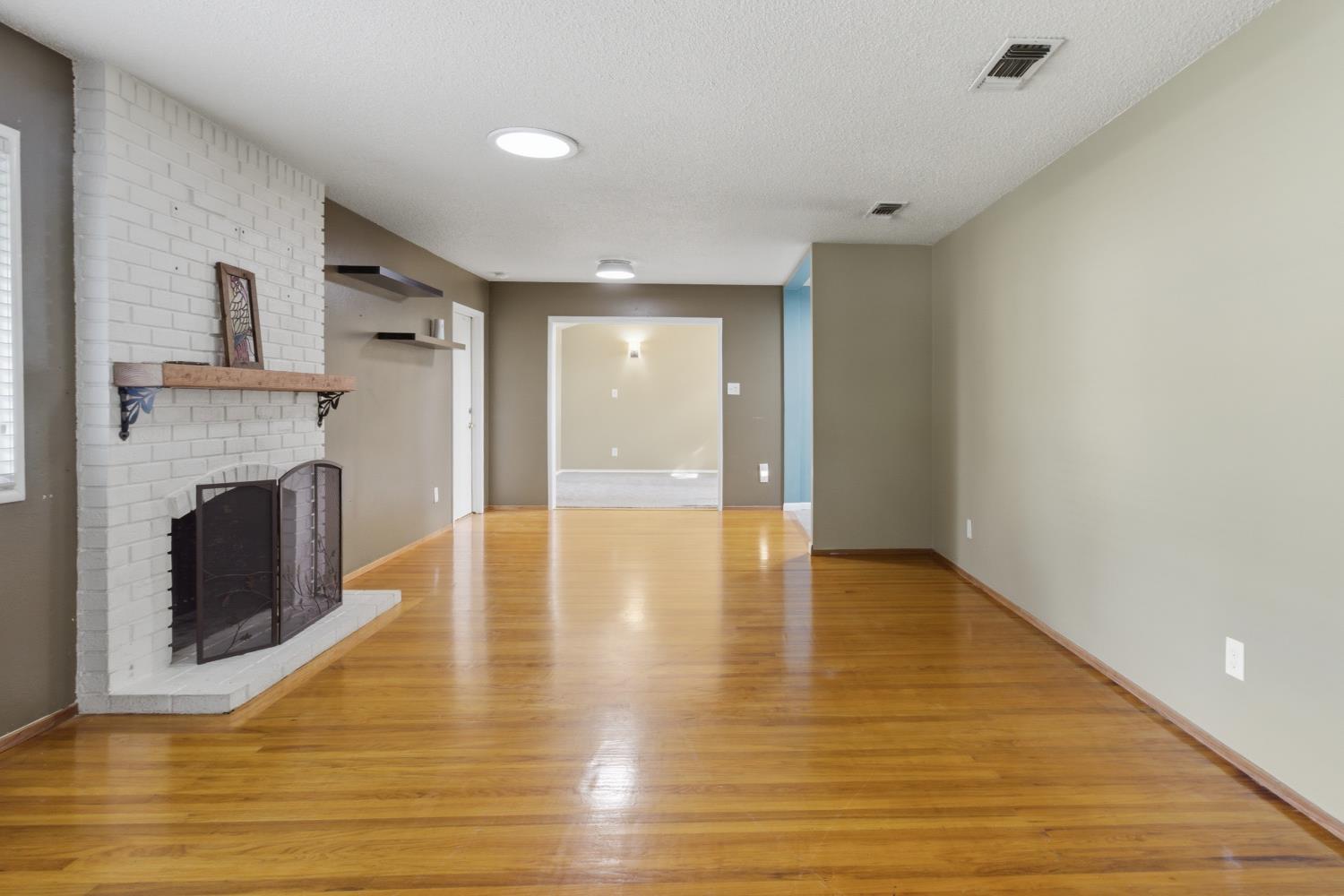 5262 Flagstone Street Carmichael, CA 95608 - Photo 5 of 31 a view of an empty room with wooden floor and a fireplace