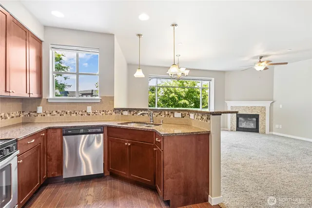 a kitchen with granite countertop a refrigerator and a stove top oven