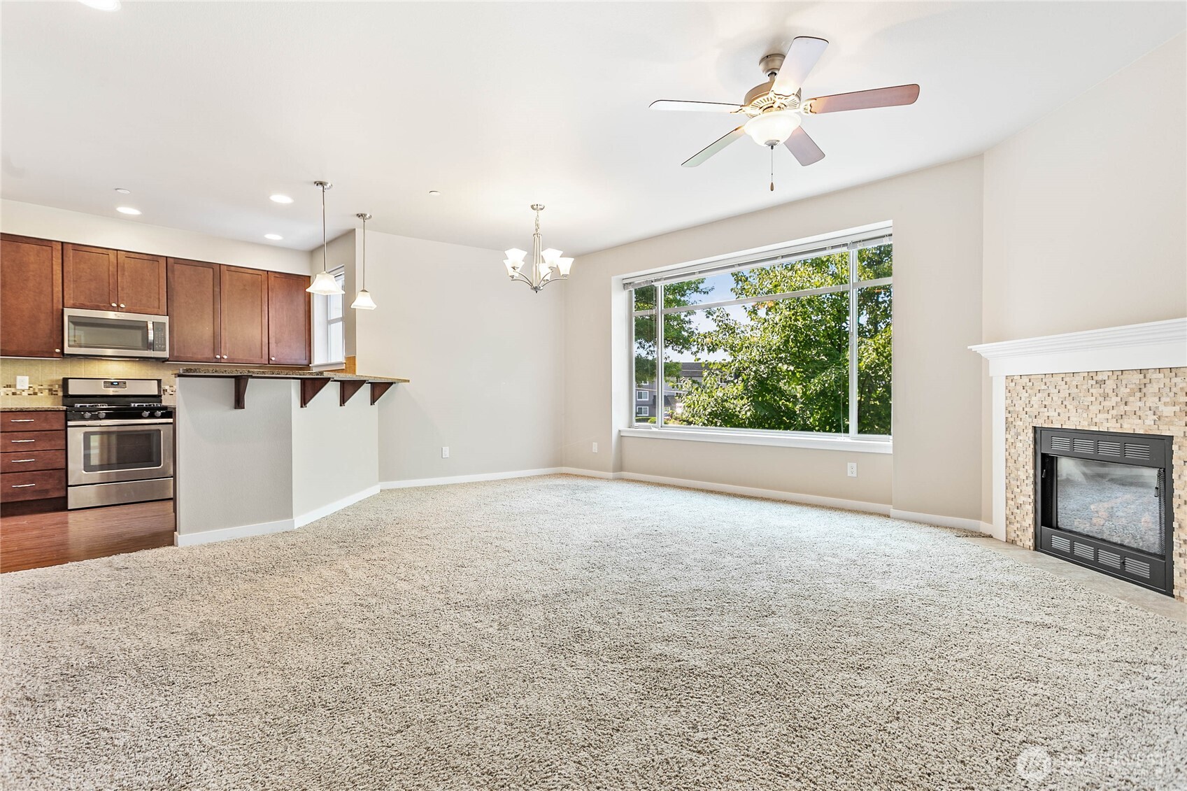8780 Depot Road, Unit 207 Lynden, WA 98264 - Photo 5 of 37 a view of a kitchen with a stove cabinets a ceiling fan and a kitchen view