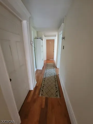 a view of hallway with wooden floor