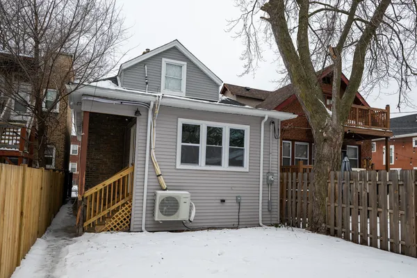 a front view of a house with a tree