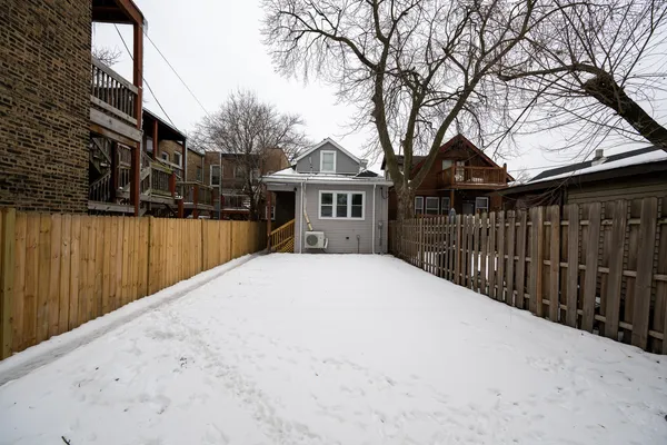 a view of a house with a wooden fence