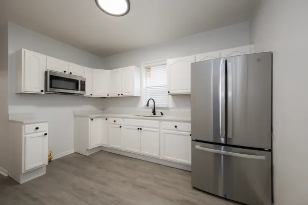 a kitchen with stainless steel appliances granite countertop a refrigerator sink and microwave