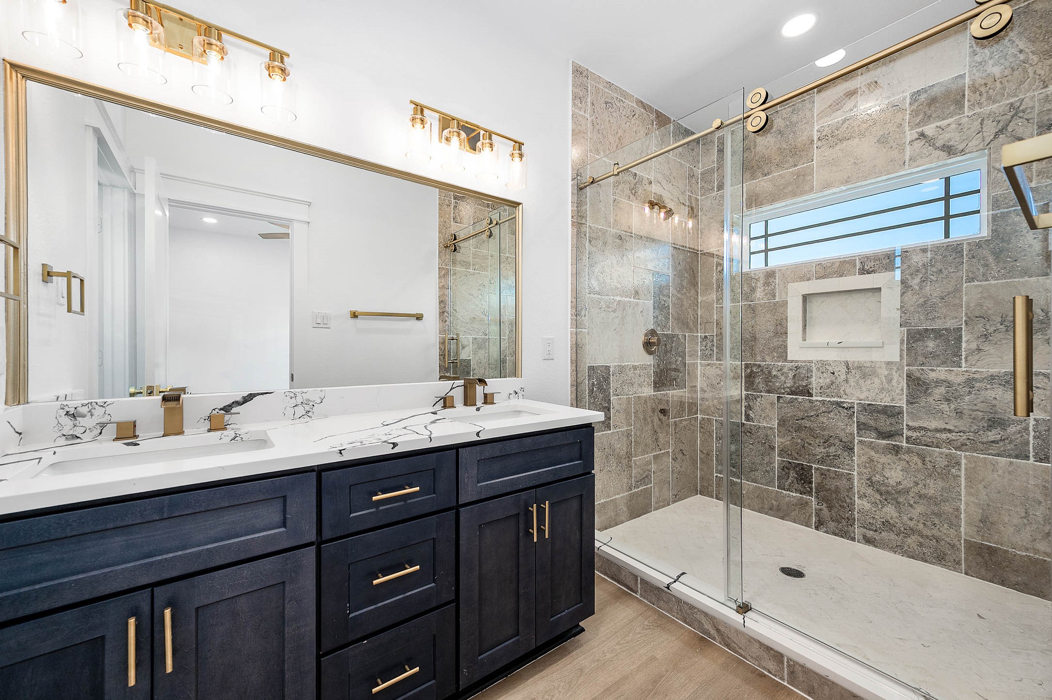 8602 Hoffman Street Houston, TX 77016 - Photo 21 of 30 Primary bathroom featuring a double vanity, custom tile shower, and elegant gold fixtures.