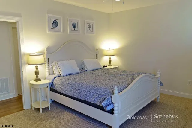 a spacious bedroom with a bed and a lamp