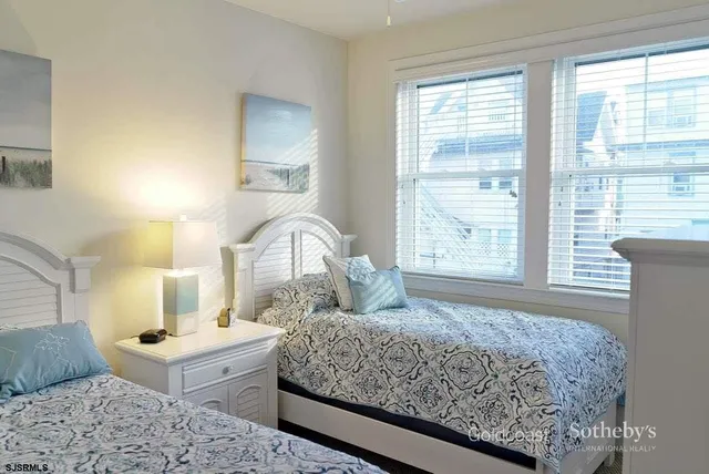 a bedroom with a bed and a dresser with windows