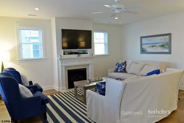 a living room with furniture a flat screen tv and a fireplace