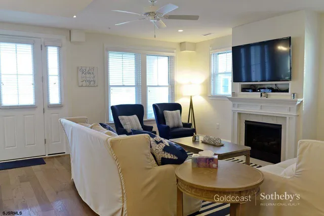 a living room with furniture a fireplace and a flat screen tv