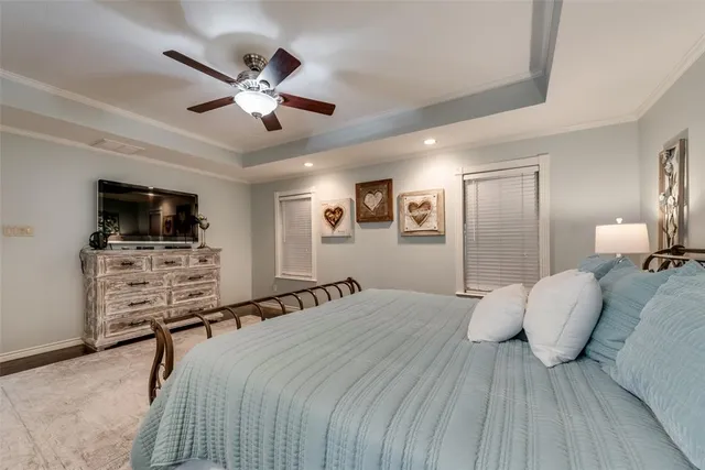 a bedroom with a bed and a flat tv screen on dresser
