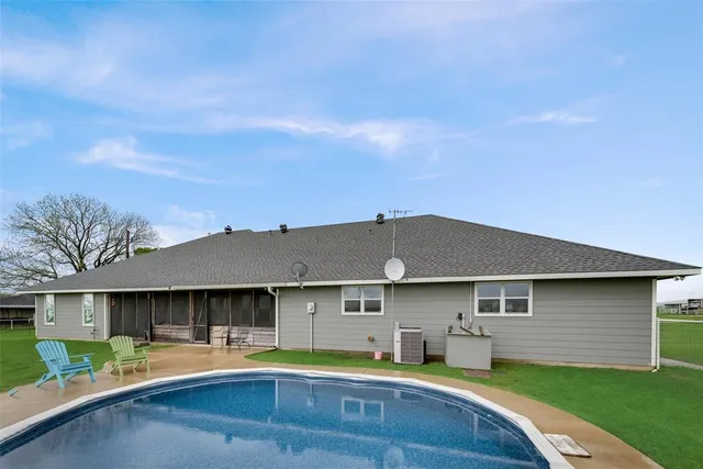 a view of a house with swimming pool and a yard
