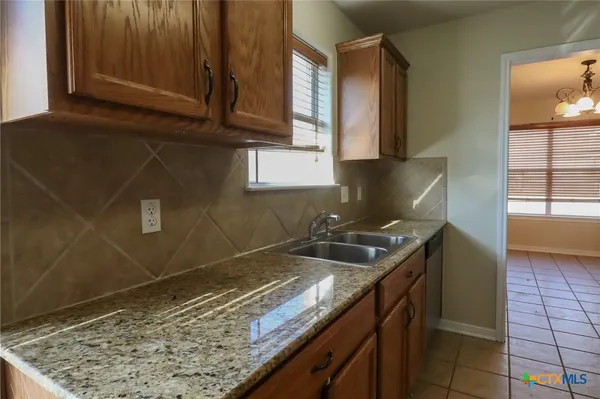 a kitchen with granite countertop a sink and a stove