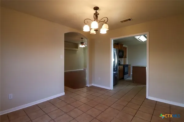 a view of a chandelier in big room and a bathroom