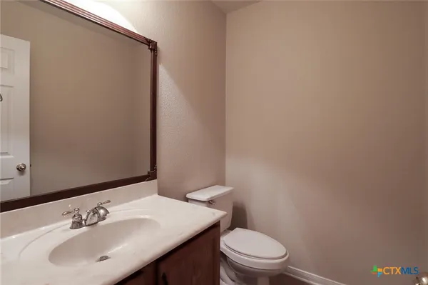 a bathroom with a sink a toilet and a mirror