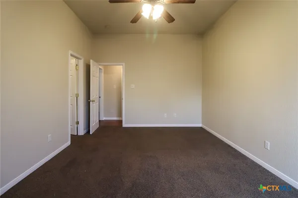 an empty room with a empty space and a ceiling fan