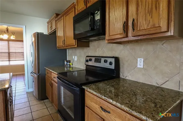 a kitchen with stainless steel appliances granite countertop a stove a refrigerator and a microwave