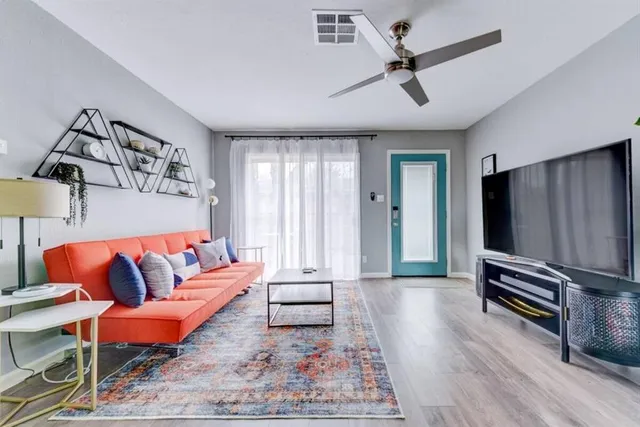 a living room with furniture a ceiling fan and a rug