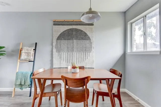 a dining room with furniture a chandelier and wooden floor