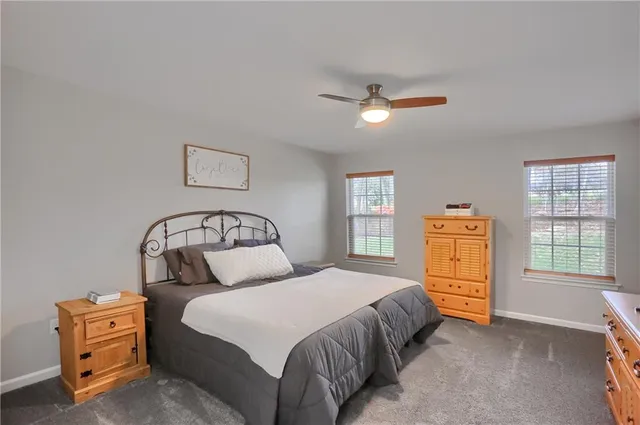 a bedroom with a bed and a flat tv screen on dresser