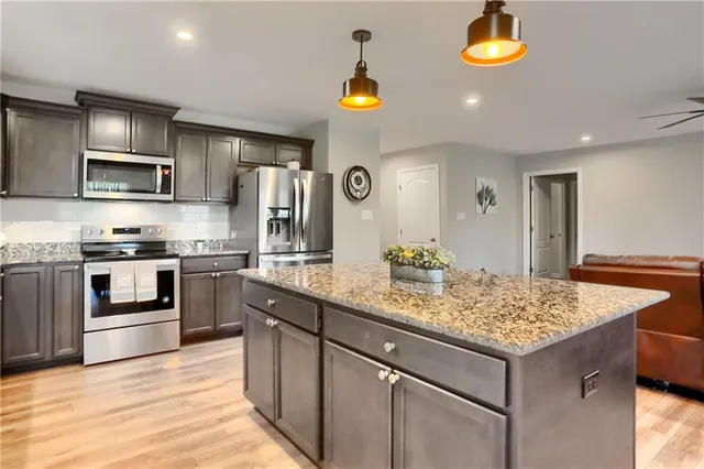 a kitchen with stainless steel appliances granite countertop a sink and a stove