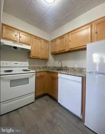 a kitchen with granite countertop cabinets stainless steel appliances and a sink