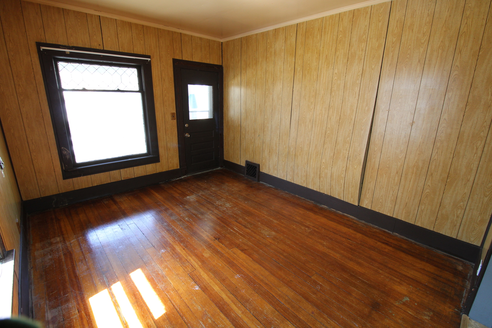 1176 22nd Street Moline, IL 61265 - Photo 4 of 19 a view of an empty room with wooden floor and a window