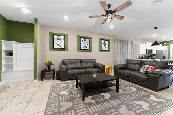 a kitchen with kitchen island granite countertop a stove a sink a microwave a dining table and chairs with wooden floor