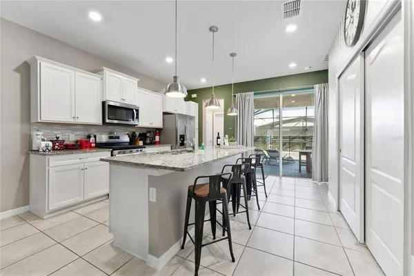 a kitchen with stainless steel appliances granite countertop a sink stove and cabinets