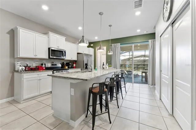 a kitchen with stainless steel appliances granite countertop a sink stove and cabinets