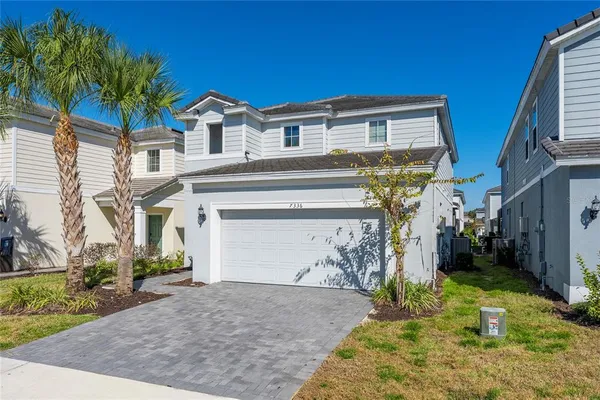 a view of a white house with large windows and a small yard