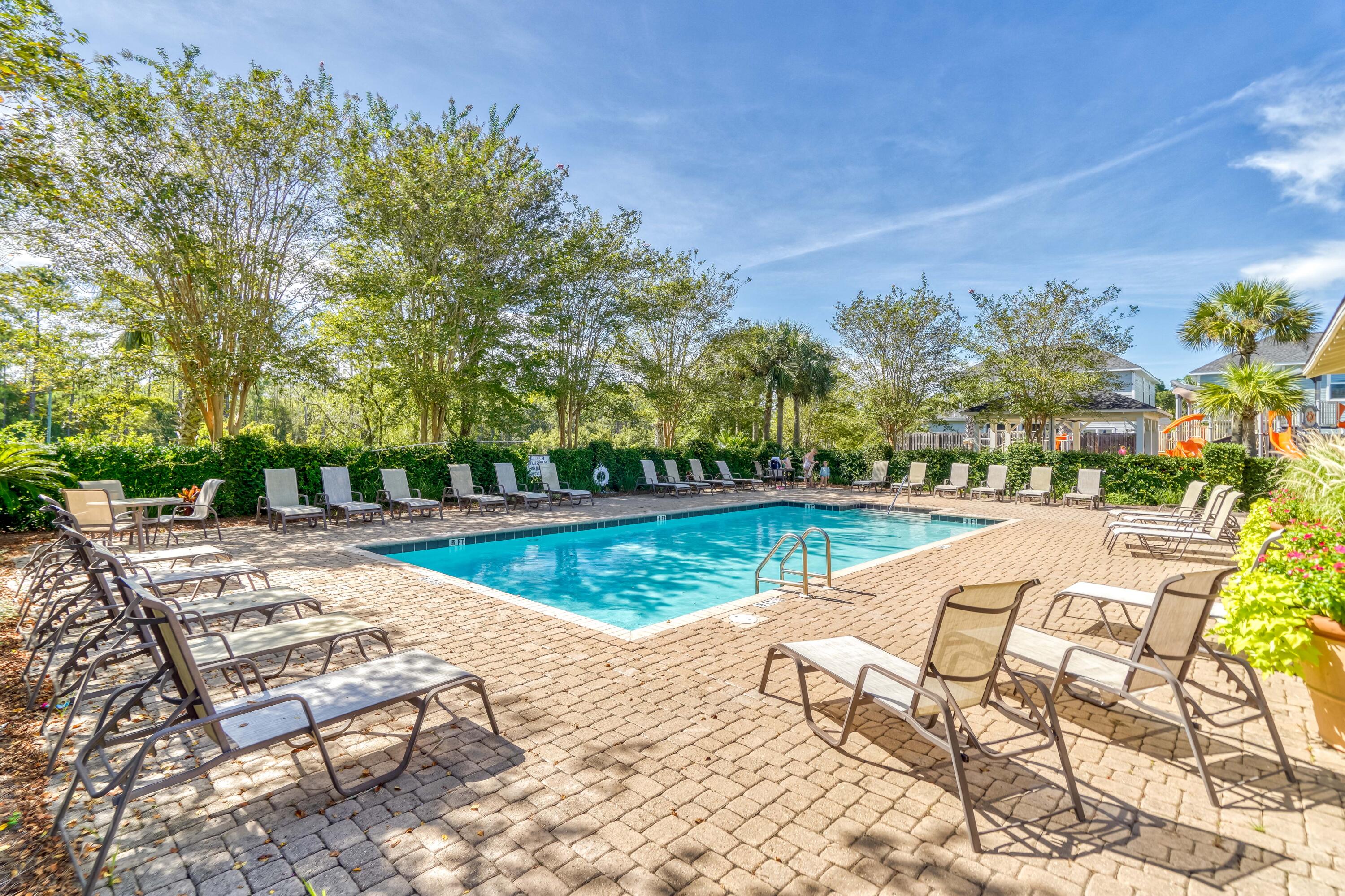 83 Hatton Court Santa Rosa Beach, FL 32459 - Photo 34 of 42 a view of swimming pool that has lawn chairs with plants and trees