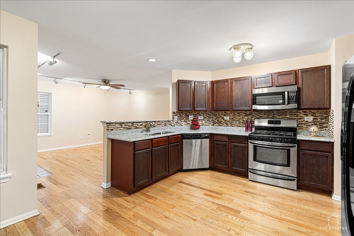 7 Eagle Court Streamwood, IL 60107 - Photo 11 of 31 a kitchen with stainless steel appliances granite countertop a stove top oven a sink and a refrigerator