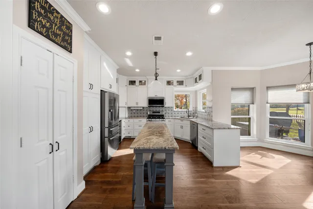 a large kitchen with stainless steel appliances kitchen island a large counter top and stainless steel appliances