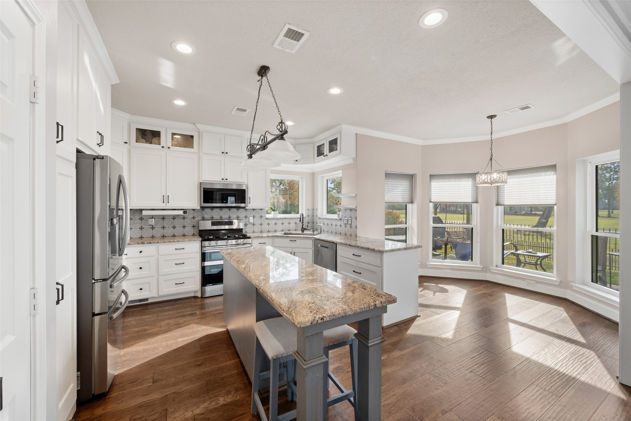 20256 Ivy Point Circle Humble, TX 77346 - Photo 15 of 36 a kitchen with stainless steel appliances granite countertop a refrigerator a oven a sink a dining table and chairs with wooden floor