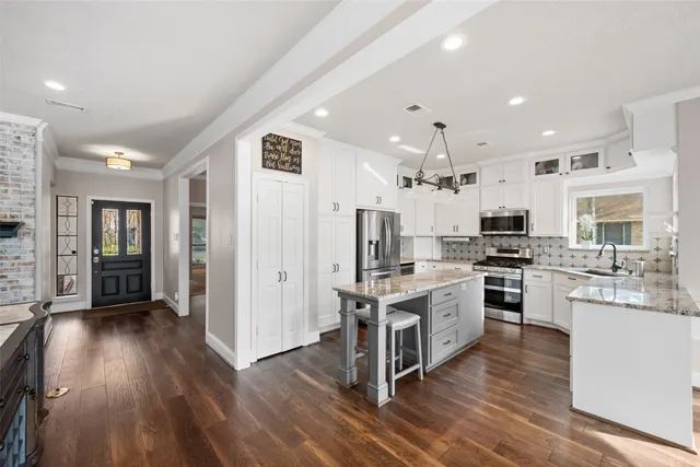 a large kitchen with stainless steel appliances kitchen island a large counter space a sink and a stove