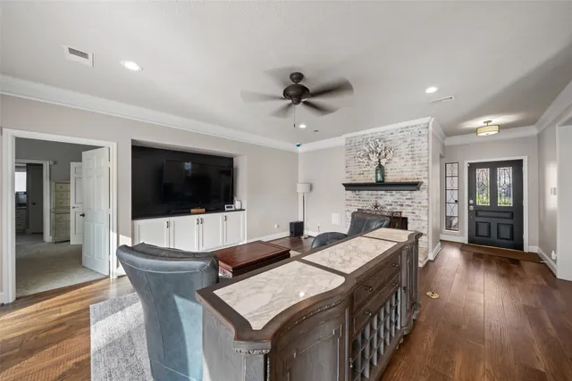 a living room with furniture a flat screen tv and kitchen view