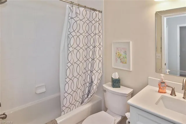 a kitchen with a sink dishwasher and white cabinets with wooden floor
