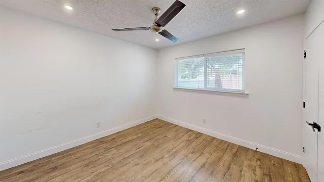 a view of a room with wooden floor and a window