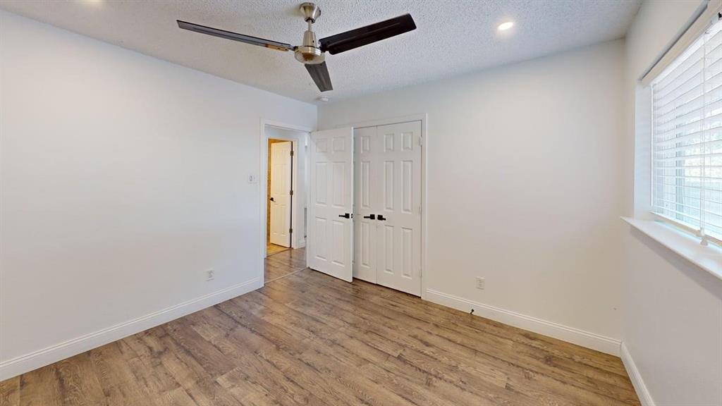 2131 Blossom Lane Richardson, TX 75081 - Photo 14 of 22 an empty room with wooden floor closet and windows
