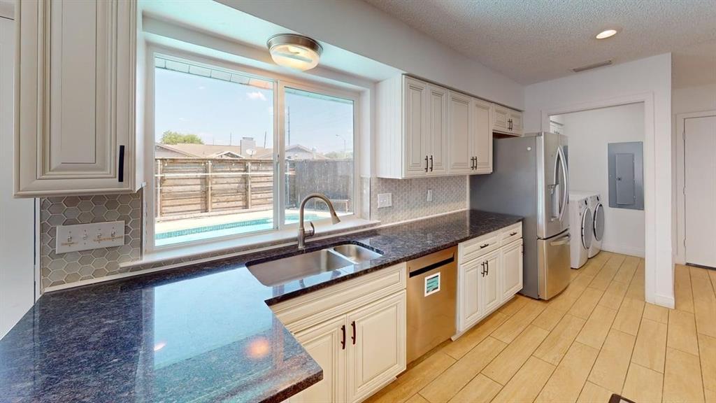 2131 Blossom Lane Richardson, TX 75081 - Photo 2 of 22 a kitchen with stainless steel appliances granite countertop a sink and wooden cabinets